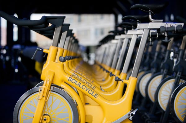 Row of bright yellow, SoulCycle cycling bikes
