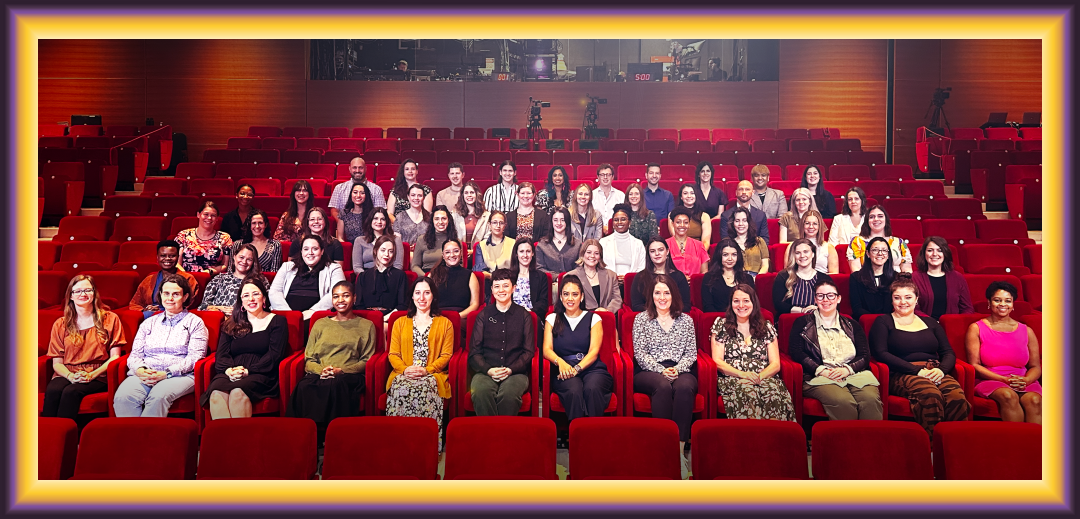 Capacity Interactive team sitting on red seats in a theatre.